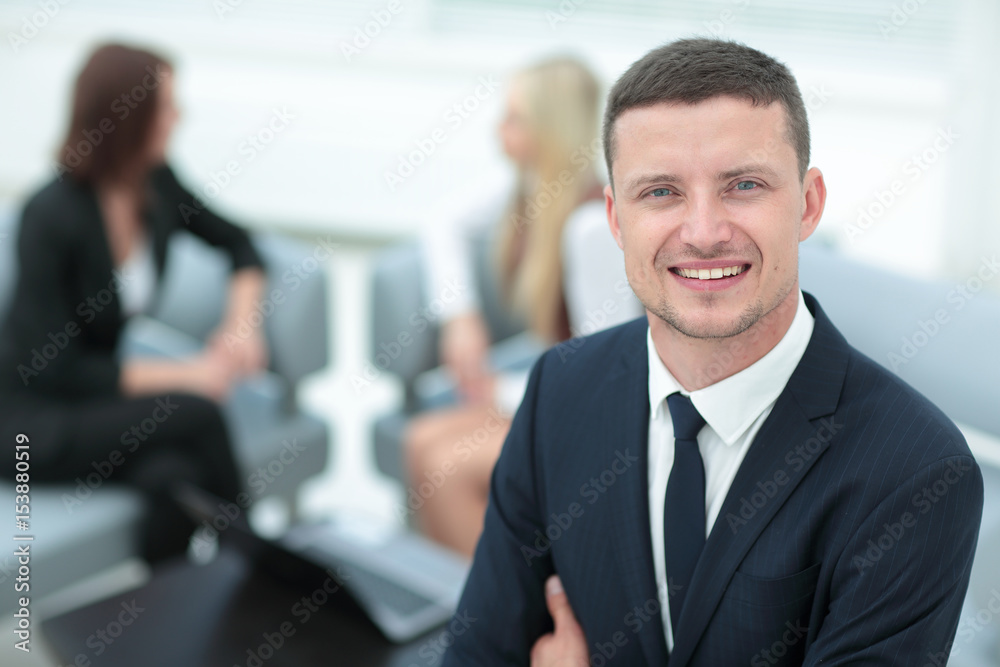 Portrait of a smiling business man with colleagues working in th Portrait of a smiling business man with colleagues working in th