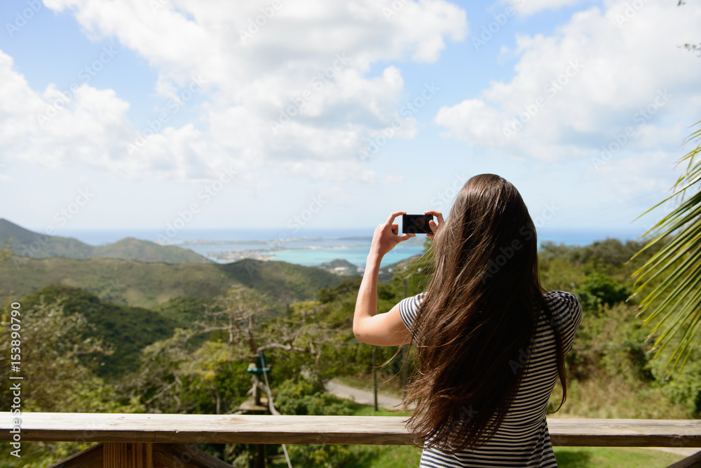 Woman taking picture of coast landscape
