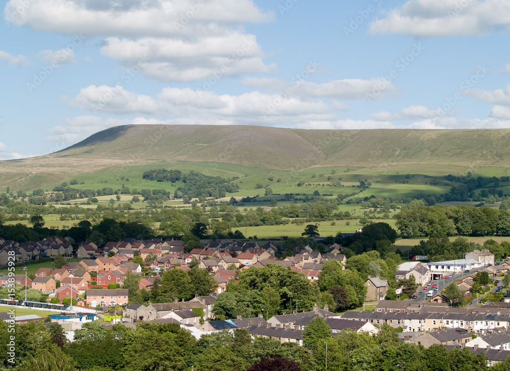 Houses on the edge of Clitheroe, Lancashire with Pendle hill rising beyond.