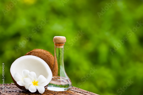 coconut oil and coconuts on green background