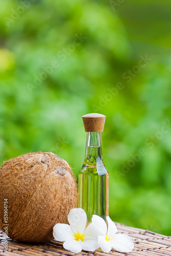 coconut oil and coconuts on green background