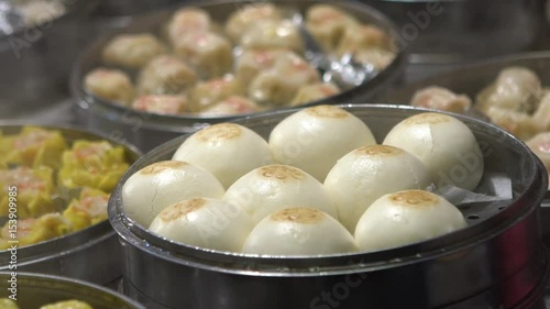 Slow motion vendor preparing and selling Shaomai and customers at Asian Street Food Market in Taiwan. Dumpling is a chinese traditional food at Oriental Night Market. Restaurant in downtown-Dan photo