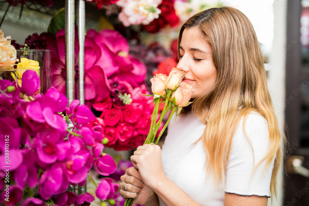Sweet woman smelling flowers in a store