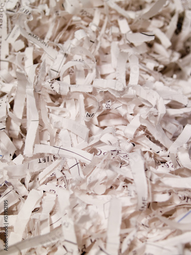 Shredded white  papers with some numbers showing, full frame.