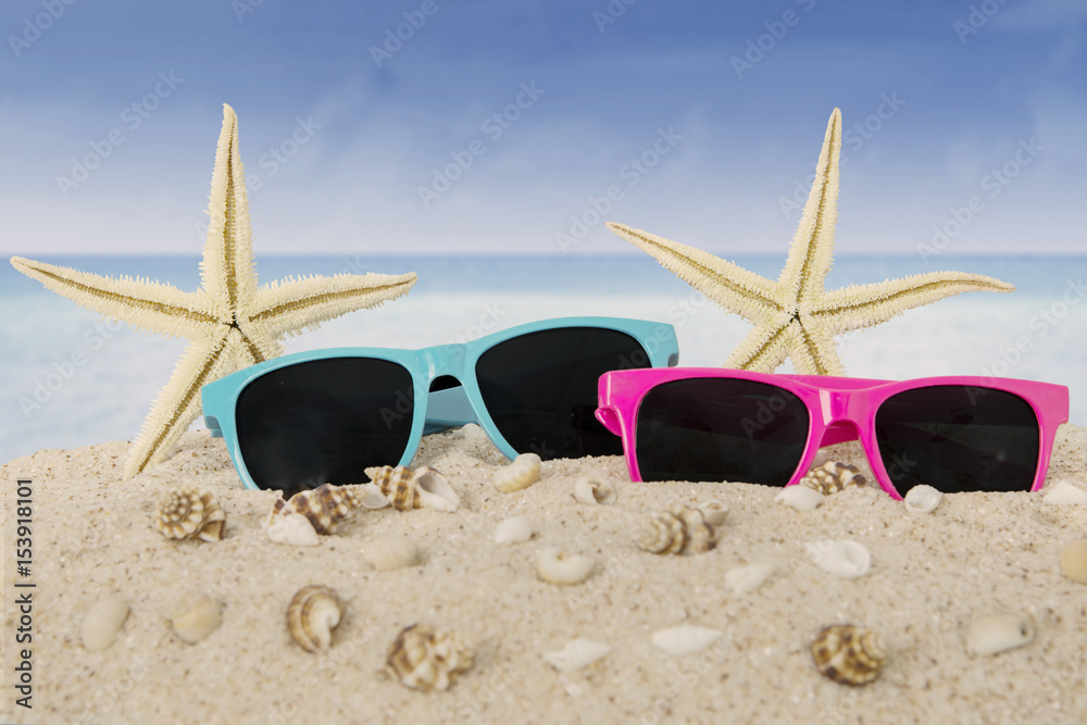 Sunglasses and starfish on beach