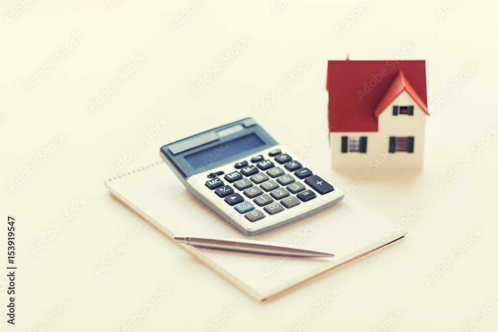 close up of home model, calculator and notebook close up of home model, calculator and notebook