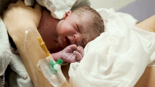 newborn baby lying on the breast of the mother