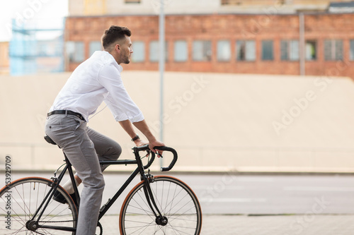 man with headphones riding bicycle on city street