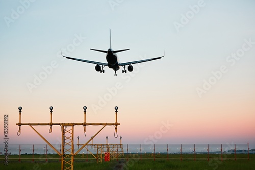 Airplane landing at the sunset
