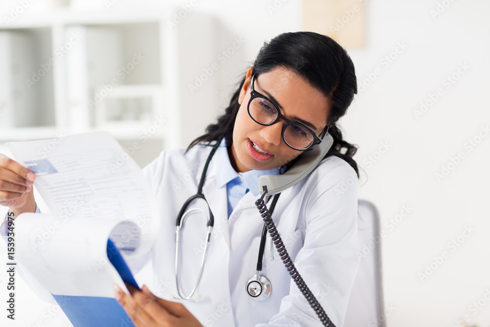 doctor with clipboard calling on phone at hospital doctor with clipboard calling on phone at hospital
