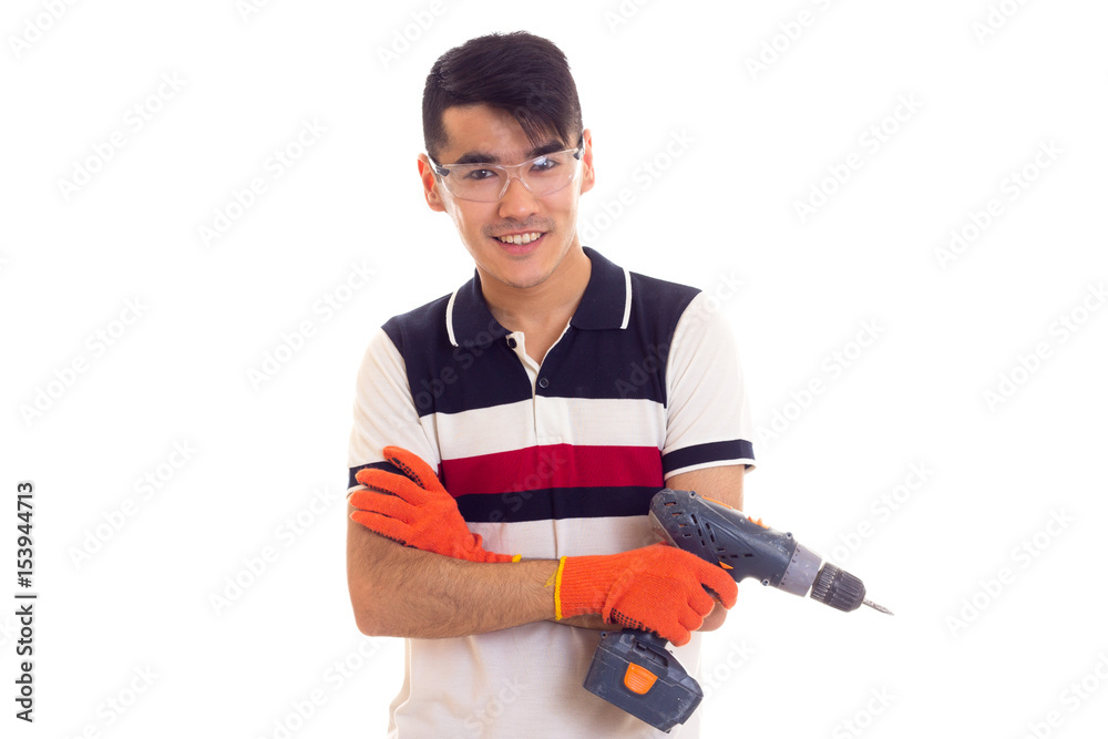 Young man with gloves and glasses holding electric screwdriver Young man with gloves and glasses holding electric screwdriver