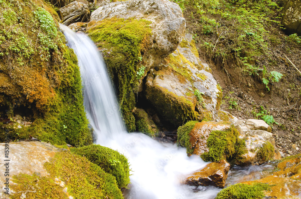 Obraz premium HDR Beautiful small waterfall of a mountain river in a forest shot on a long exposure