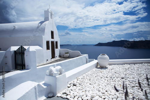 White house surrounded by white decoration and a view to the caldera on Santorini island, Greece