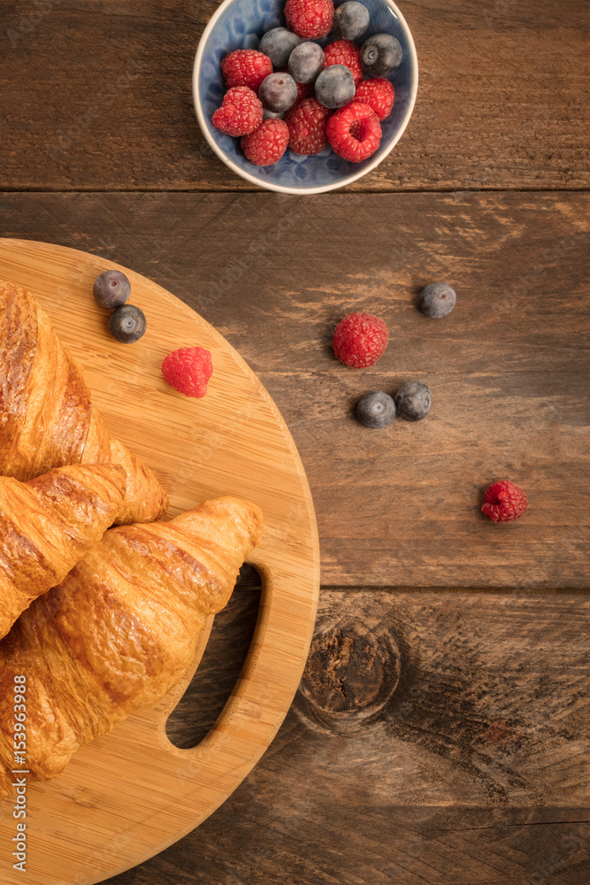 Crunchy French croissants with fresh raspberries and blueberries Crunchy French croissants with fresh raspberries and blueberries
