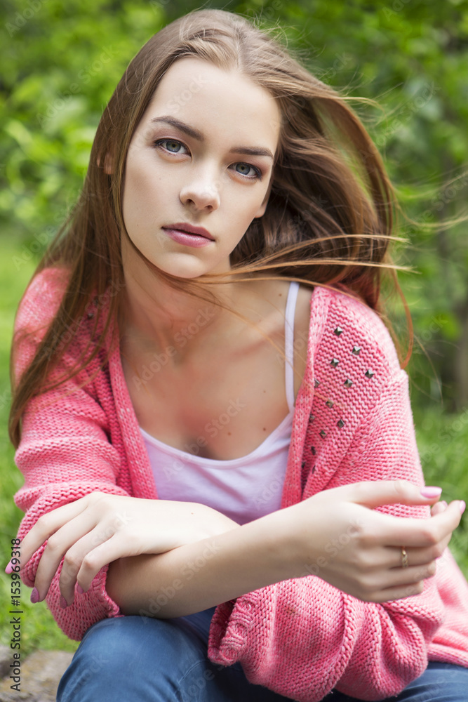 Beautiful brunette woman in neutral casual outfit walking in park. Lifestyle portrait. Summer day