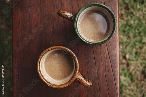 Overhead view of coffee cups on wooden table