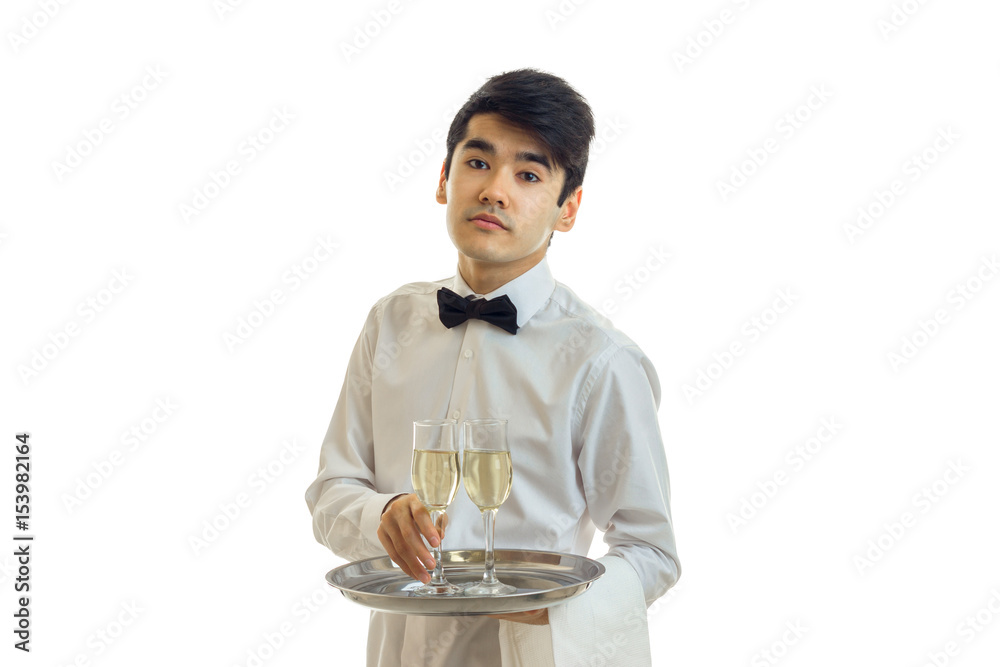 beautiful tired young waiter holding a tray before him with a glass of champagne beautiful tired young waiter holding a tray before him with a glass of champagne