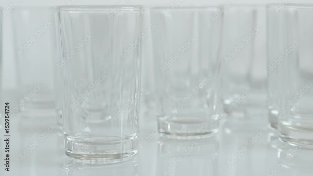 Close-up of shot glass pieces on white background slow tilt 4K 2160p 30fps UltraHD footage - Tilting on empty transparent spirits or liquor drink glasses 3840X2160 UHD video Close-up of shot glass pieces on white background slow tilt 4K 2160p 30fps UltraHD footage - Tilting on empty transparent spirits or liquor drink glasses 3840X2160 UHD video