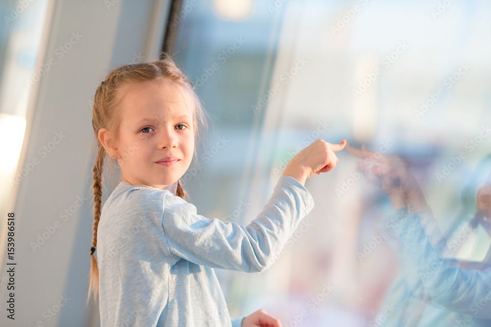 Adorable little girl in airport near big window waiting for boarding Adorable little girl in airport near big window waiting for boarding