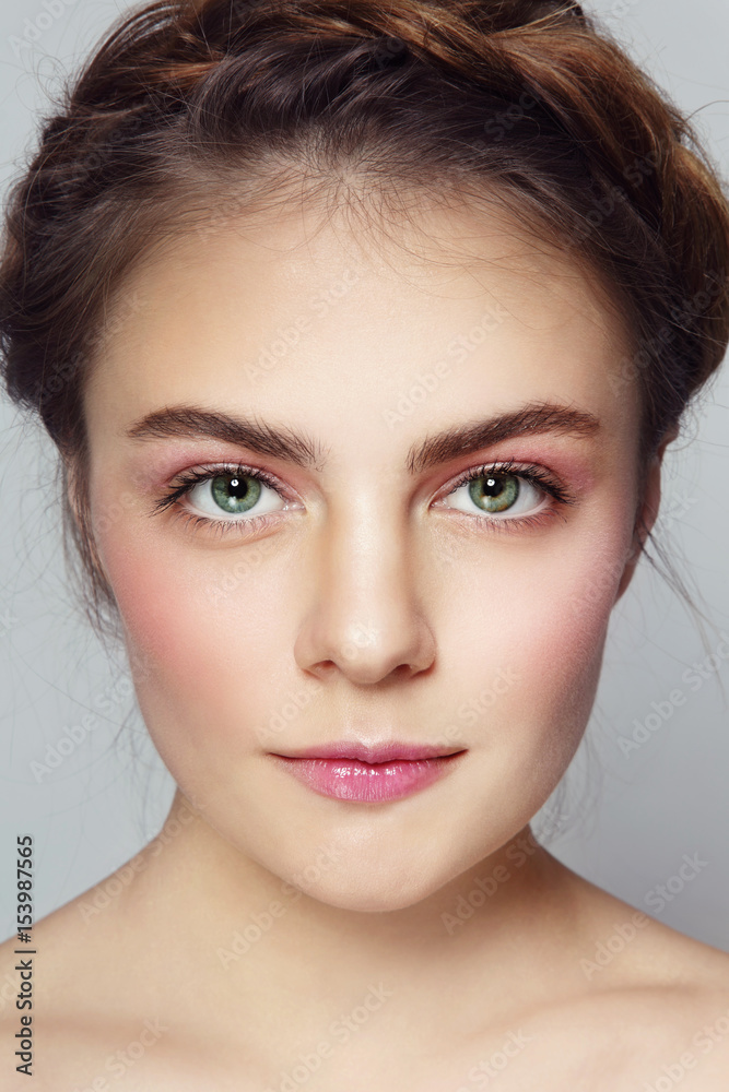 Naklejka premium Close-up portrait of young beautiful girl with clean make-up and braids