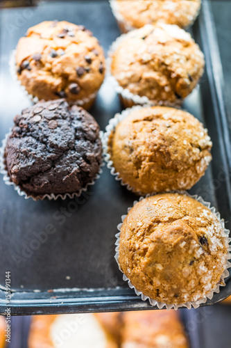 Vanilla and chocolate cake muffins in liners on display with sugar granules