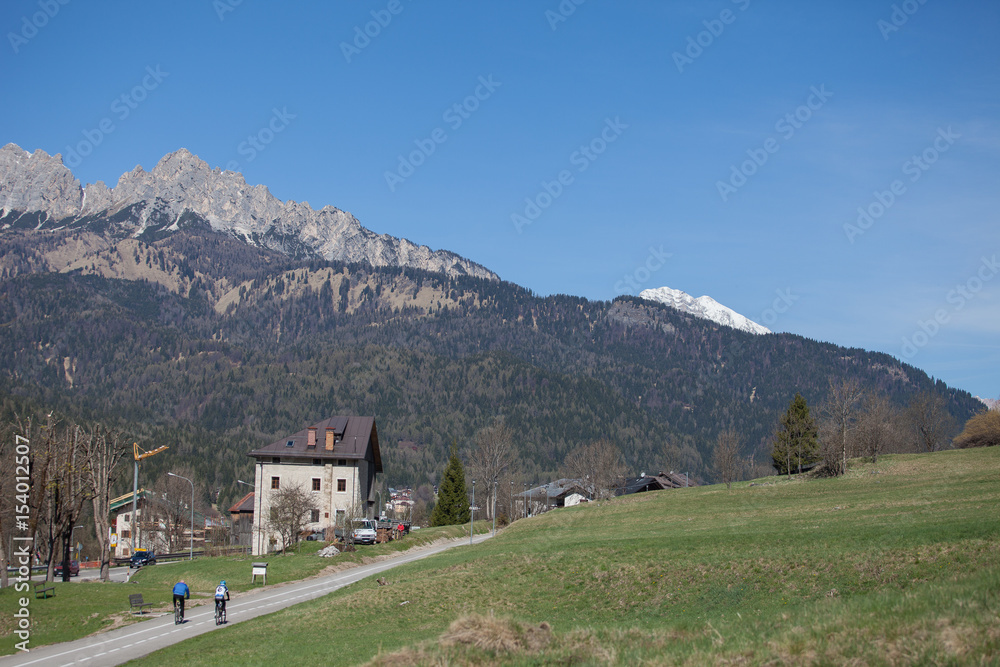 Cyclists on bicycle path towards Cortina d'Ampezzo, Dolomites, Italy