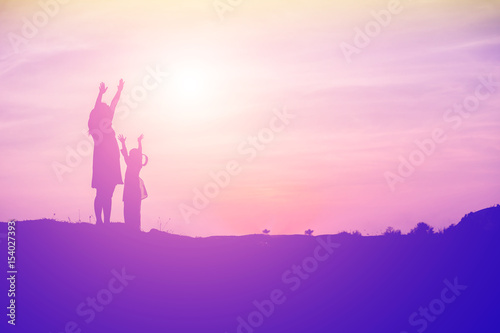 Mother encouraged her daughter out of the shadows at sunset.