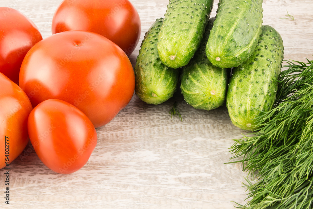 Cucumber, tomato, pepper and fennel on a white wooden background close up. Cucumber, tomato, pepper and fennel on a white wooden background close up.