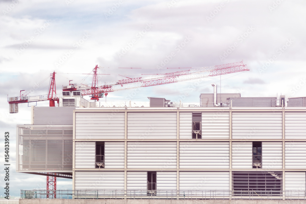 Naklejka premium Crane and building construction site against blue sky.