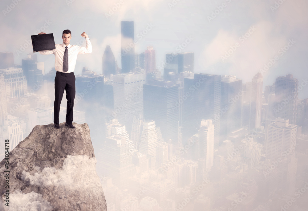 Winner urban businessman on top of stone Winner urban businessman on top of stone