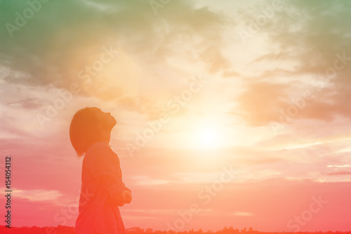 Fotografie Silhouette of woman praying over beautiful sky background