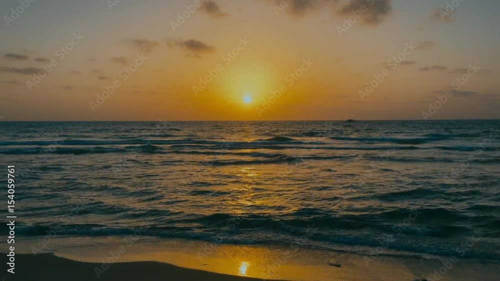 Handheld shot of dawn over the calm sea, waves splashing over the sandy shore. 4K color graded footage Handheld shot of dawn over the calm sea, waves splashing over the sandy shore. 4K color graded footage