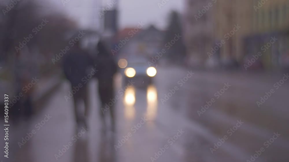 Loving Couple Walks in the Rain Through the City Streets, Spring, Autumn in the City, the First Snow in the City. Out of Focus Loving Couple Walks in the Rain Through the City Streets, Spring, Autumn in the City, the First Snow in the City. Out of Focus