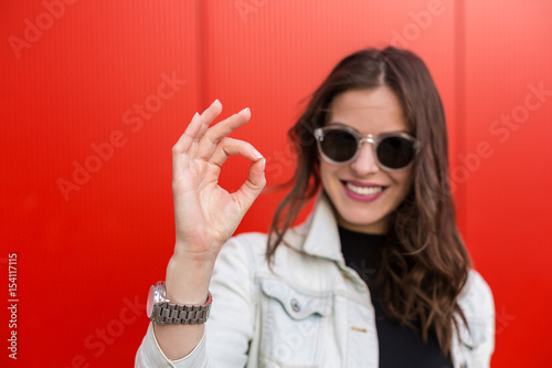 Woman standing near a red wall