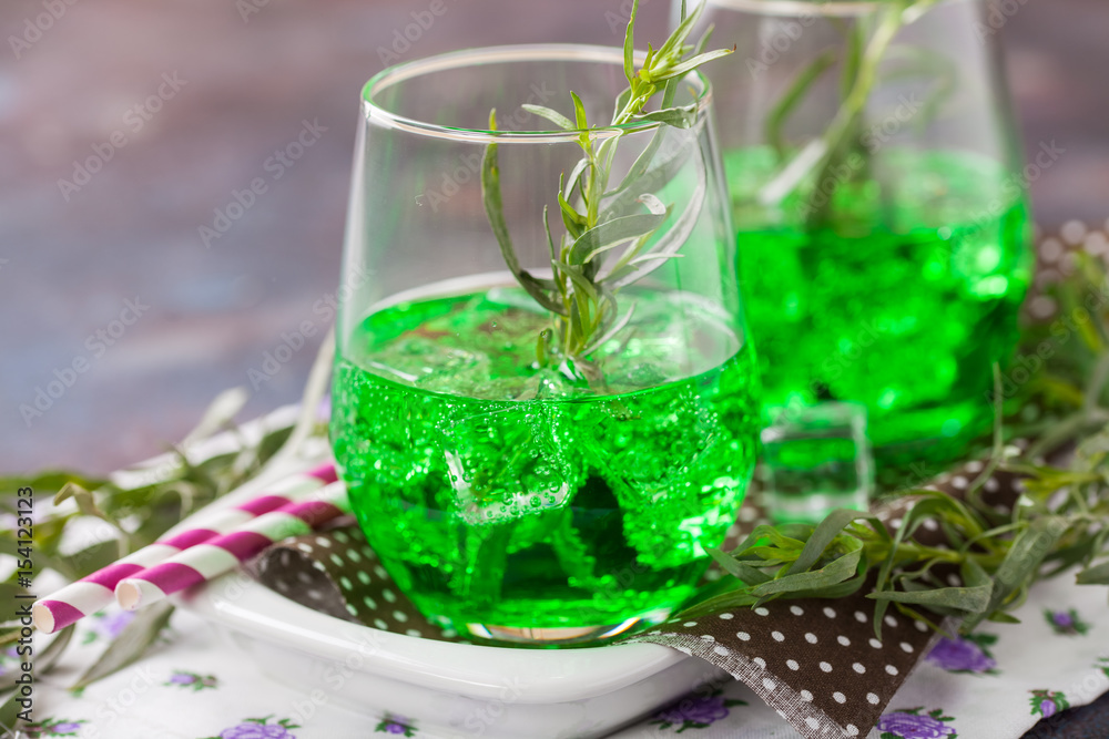 Drink from an estragon with ice in a glass on a table. Selective focus. Copy space Drink from an estragon with ice in a glass on a table. Selective focus. Copy space
