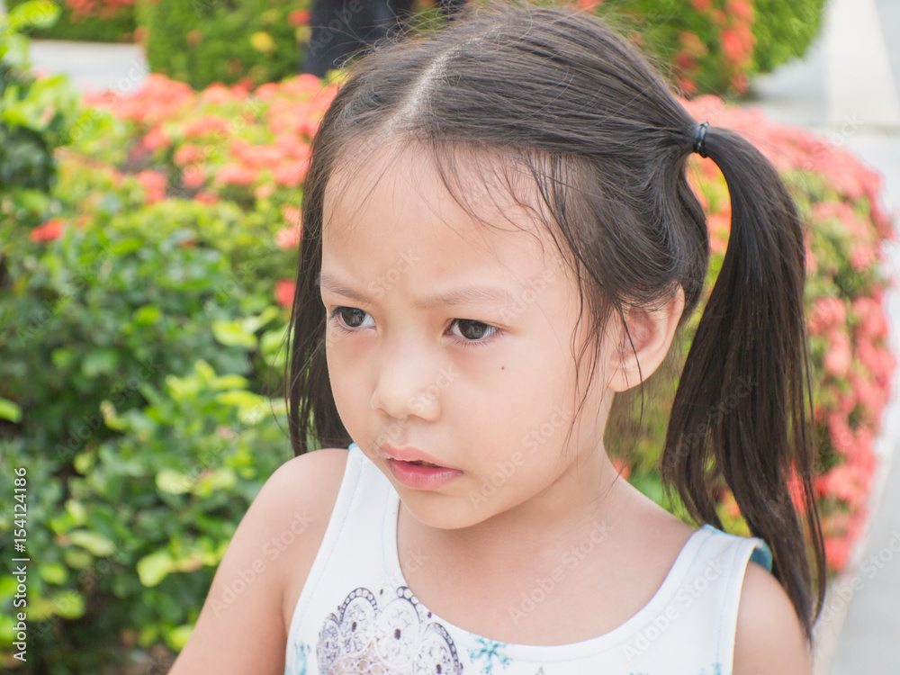 Cute asian child look at something in the park on a hot day.