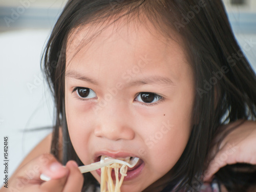 Cute asian Kids eat noodles.