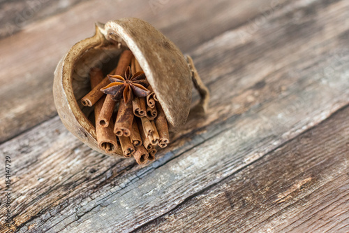 Ground cinnamon cinnamon sticks tied with jute rope on old wooden background in rustic style