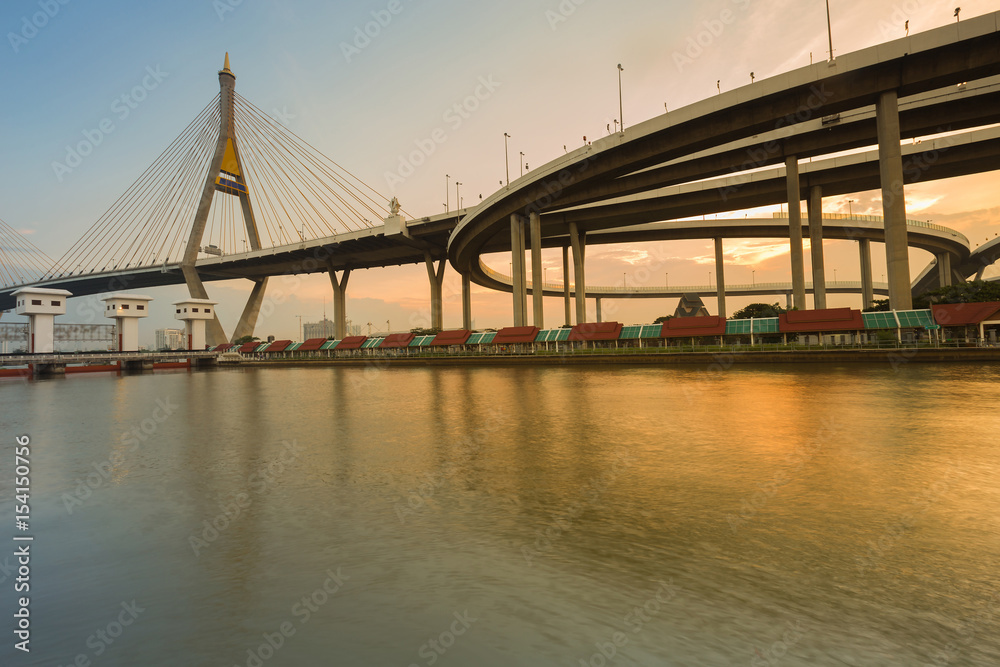 City suspension connect highway interchange river front during sunset