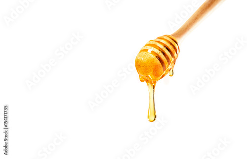 Valokuvatapetti honey on wooden dipper white background
