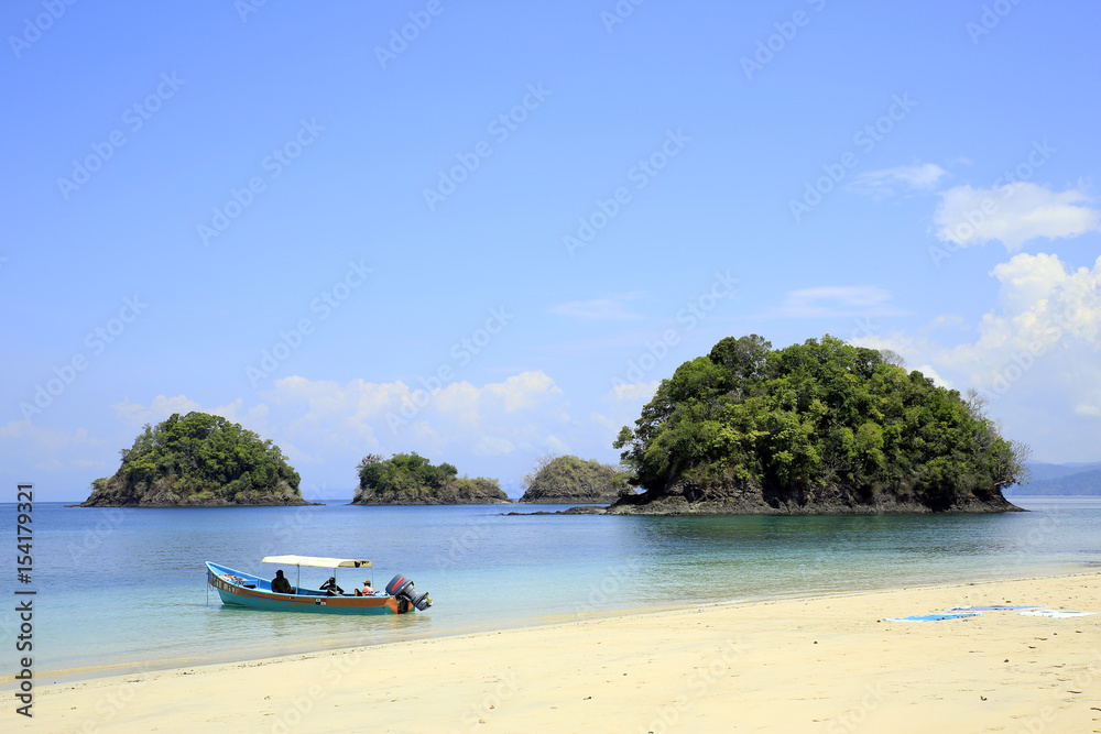 Fototapeta premium Beach with Small Isles and a Dive Boat. Coiba National Park, Panama