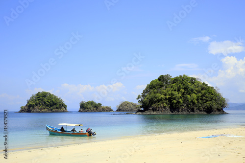 Fototapeta Naklejka Na Ścianę i Meble -  Beach with Small Isles and a Dive Boat. Coiba National Park, Panama