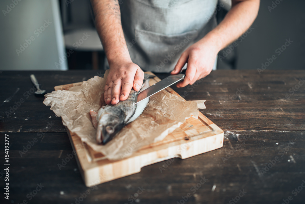 Chef hands with knife cut up fish on cutting board Chef hands with knife cut up fish on cutting board