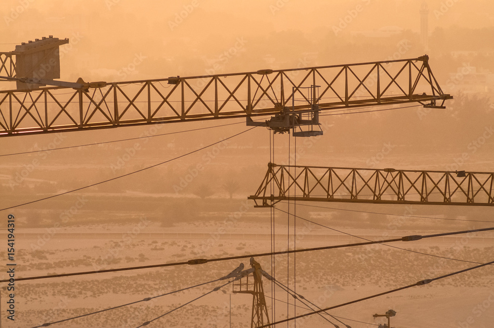 Naklejka premium back-lit construction cranes detail