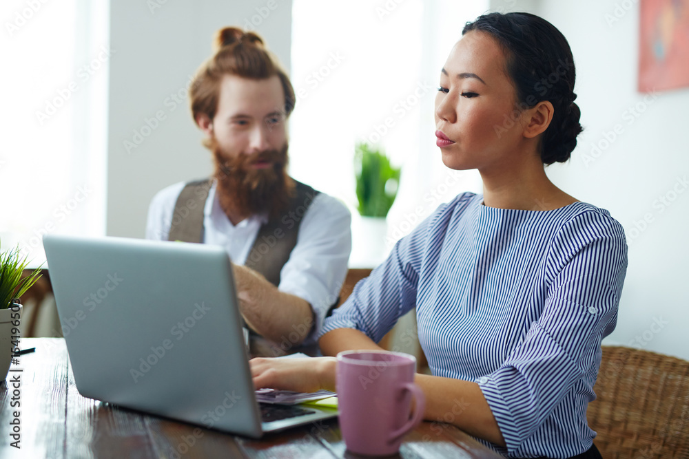 Portrait of two creative business people, man and woman, meeting to discuss work in modern design studio Portrait of two creative business people, man and woman, meeting to discuss work in modern design studio