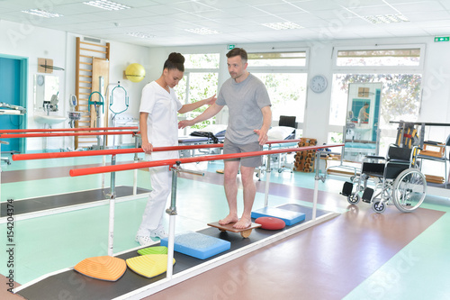 Bild auf Leinwand Man balancing with physiotherapist