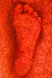 trace foot imprint on the rock in the gradients of the red and orange to bright light abstract background