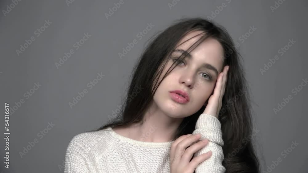 Slow motion video portrait of beauty young brunette woman portrait in white fashion female pullover Slow motion video portrait of beauty young brunette woman portrait in white fashion female pullover