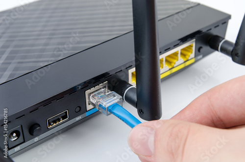 Man plugs internet cable into the router