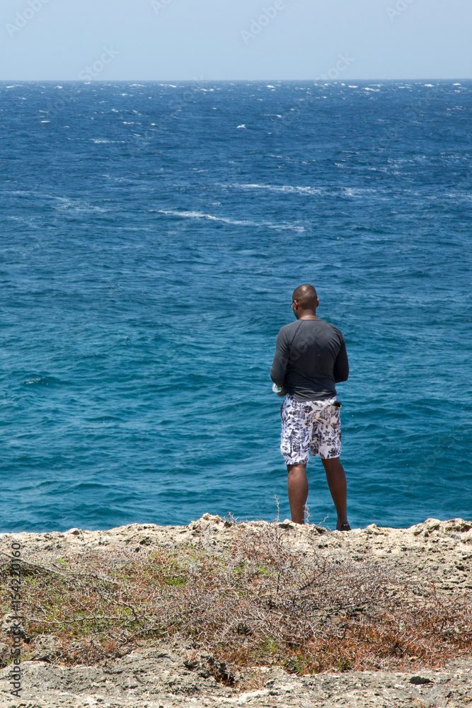 Junger Mann schaut auf das Meer
